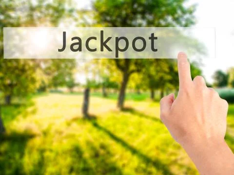 Jackpot - Hand pressing a button on blurred background concept . Business, te Stock Photos
