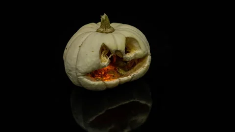 Jack's pumpkin mask rots on a black background shimmering next to it on a black Stock Footage 259268385