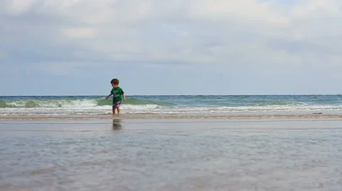 JacobRunningOnBeachToCamera Stock Footage 1013217