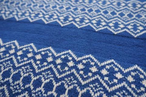 Jacquard knitted pattern. Knitted with white thread rhombuses and zigzags on  스톡 사진