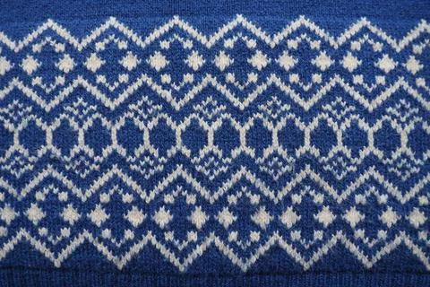 Jacquard knitted pattern. Knitted with white thread rhombuses and zigzags on  Stock Photos