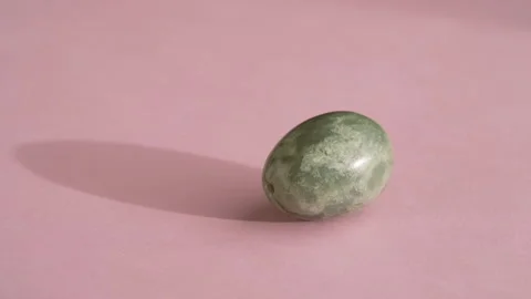 Jade egg spinning on pink background Video stock 168035626
