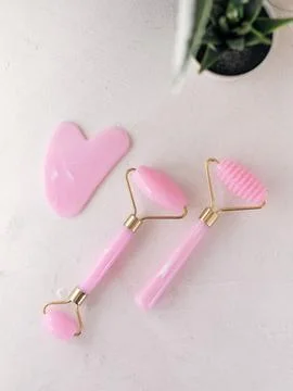 Jade roller and gua sha set on marble Photos