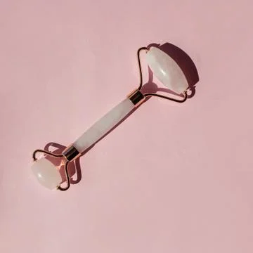 Jade roller isolated on pink background 스톡 사진