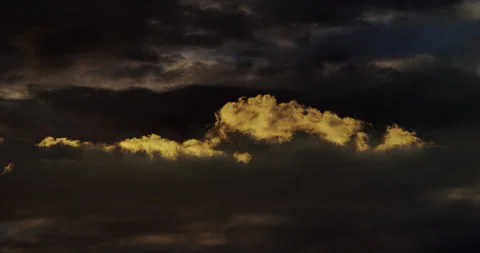 Jagged clouds create a striking focal point before a dense layer of dark clouds. Stock Footage 346794015