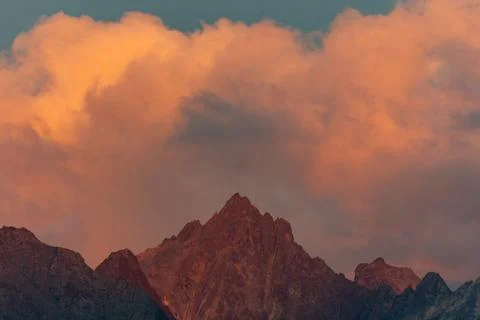 Jagged Mountain Peak at Sunset With Dramatic Orange Clouds and Golden Alpin.. Stock-Fotos