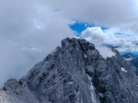 Jagged Mountain Ridge Emerging Through Dense Cloud Cover Stock Photos