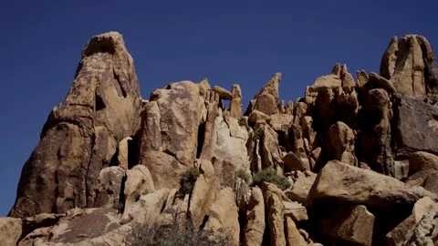 Jagged red rock formations under a clear blue sky Stock Footage 329559800