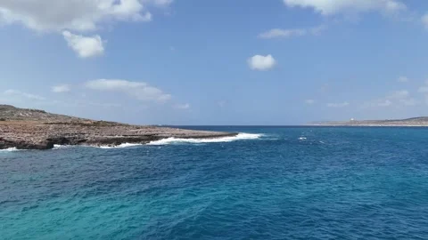 Jagged reef point cuts through turquoise sea malta aerial drone footage white Stock Footage 343594921