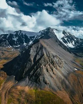 Jagged Triangular Mountain Peak Under Dramatic Clouds Stock Photos