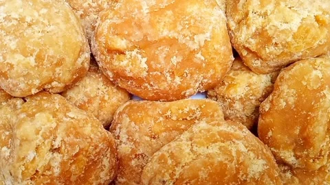 Jaggery or Gur pieces texture background rotating, top view. Organic sugar cane Stock Footage 282583877