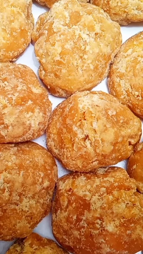 Jaggery or Gur pieces texture background rotating on white, top view Stock Footage 283086631