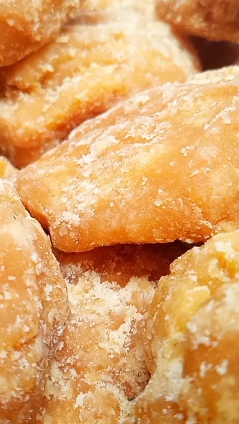Jaggery or Gur pieces texture background rotating. Organic brown cane sugar.. Stock Footage 283088920
