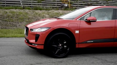 Jaguar i pace orange front end car on race track Stock Footage 155607462