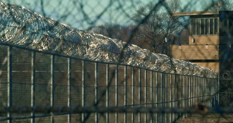 Jail, correctional facility. Razor wire fencing, gaurd tower. Rack focus Stock Footage 143761509