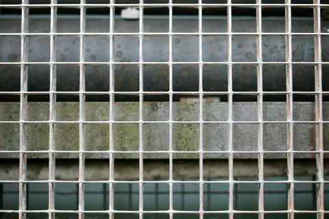 Jail metallic window with small quadrants diagonal strait lines macro backgro Stock Photos