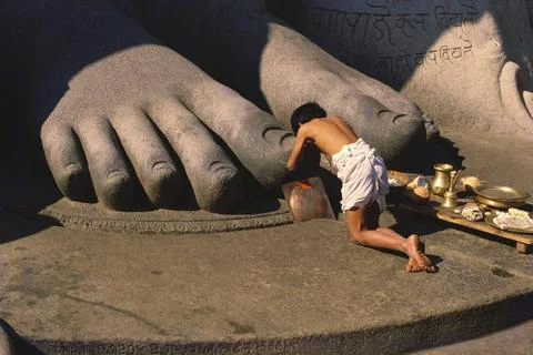 Jain devotee bow down on feet of monolithic statue of jain saint Gomateshw... Stock Photos