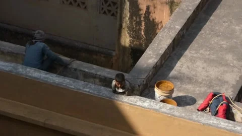 Jaipur- Boy standing at rooftop looking at tourist walking at Amber Palace Stock Footage 197003320