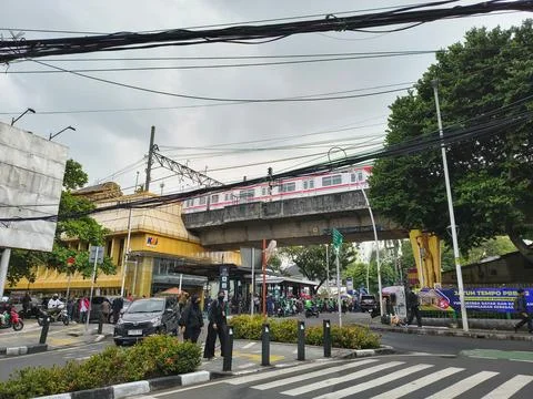 Jakarta commuter train passing elevated railway above busy street Stock Photos