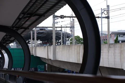Jakarta MRT Train on Elevated Viaduct Framed Through Footbridge Arch Stock Photos
