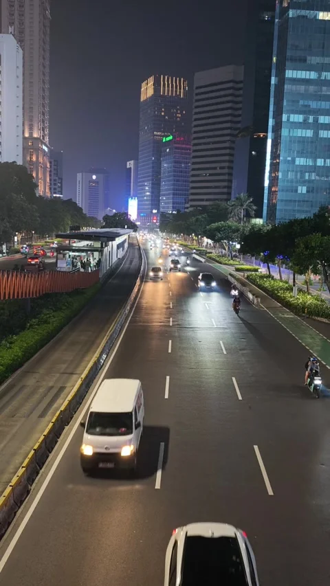 Jakarta Night Traffic with Dedicated Bus Rapid Lane and High Rise Building Stock Footage 339160621