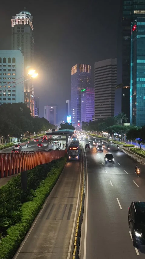 Jakarta Night Traffic with Dedicated Bus Rapid Lane and High Rise Building Stock Footage 339162964