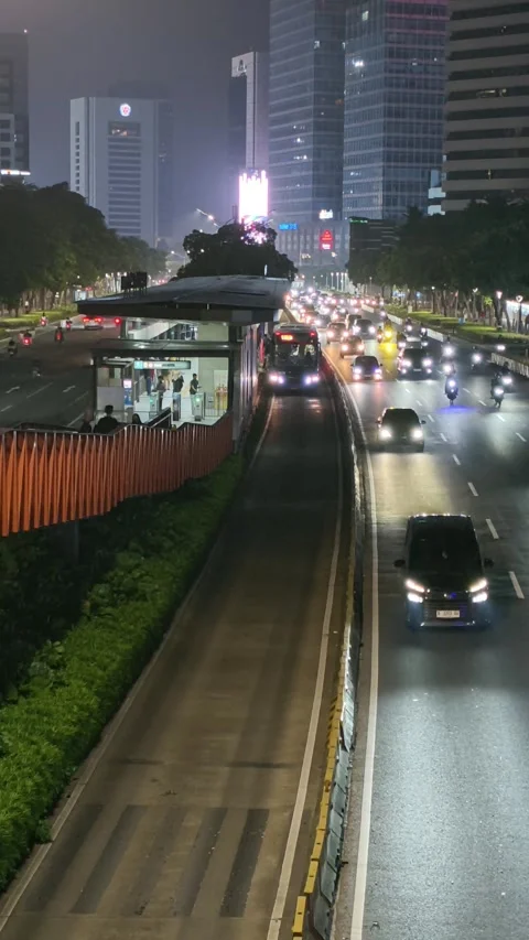 Jakarta Night Traffic with Dedicated Bus Rapid Lane and High Rise Building Stock Footage 339164657