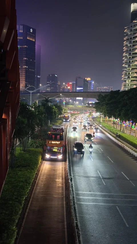 Jakarta Night Traffic with Dedicated Bus Rapid Lane and High Rise Building Stock Footage 339166346
