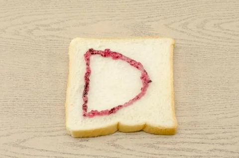 Jam alphabet on sliced bread Stock Photos