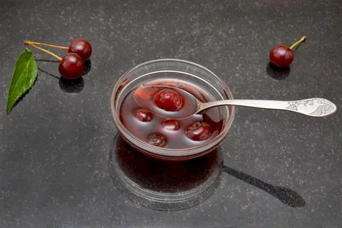 Jam and cherry berries on a black table Stock Photos