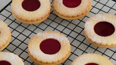 Jam cookies are on the wire rack. Female hands a making homemade biscuit Video stock 145364509