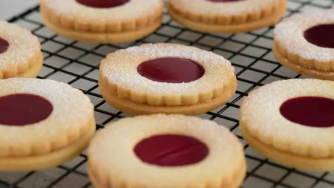 Jam cookies are on the wire rack. Female hands a making homemade biscuit Stock Footage 146503066