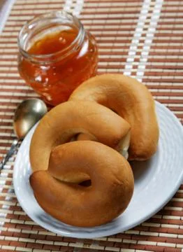 Jam jar and pretzel on the table close-up Stock Photos