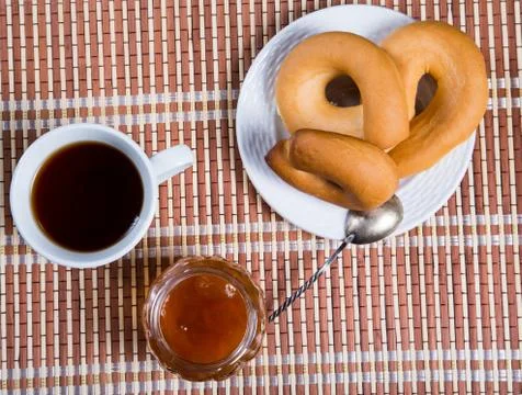 Jam jar and pretzel on the table close-up Stock Photos