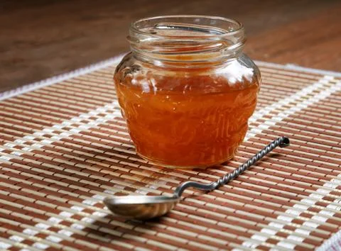 Jam jar with a spoon on a close-up table Stock Photos