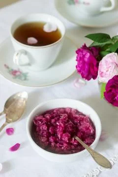 Jam from the petals of the Damascus rose, a cup of green tea and a vase of ro Stock-Fotos