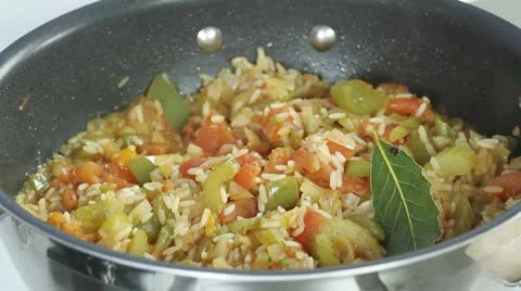 Jambalaya being made: sliced sausages and prawns being added to a rice and Stock Footage