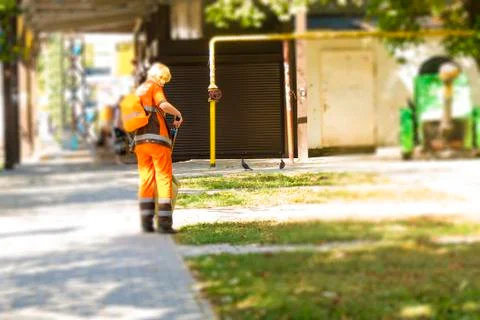 The janitor cleans the garbage against the backyard yard. Street cleaning. The Foto stock