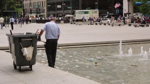 Janitor or grounds keeper cleaning fountain in downtown Chicago Stock Footage 79697270
