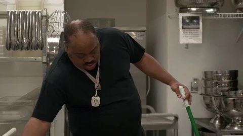 Janitor sweeping the floor at the kitchen. Видео 76721584