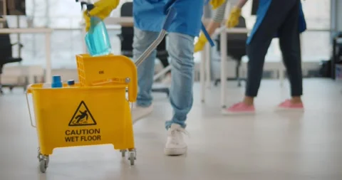Janitor taking detergent spray from yellow cart to clean office windows Stock-Footage 147384697