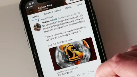 JANUARY 17, 2023: Scrolling Andrew Tate Twitter Profile Page on an iPhone Stock Footage 230285487