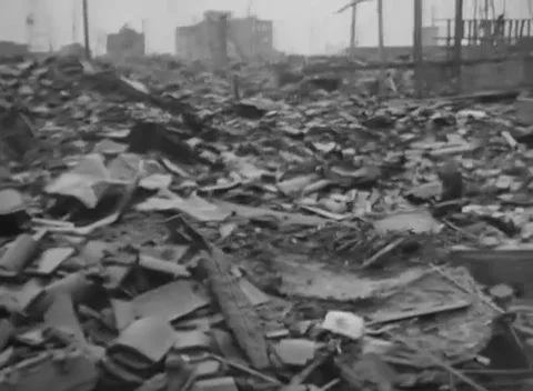 JAPAN - 1945: Cleared rubble expanse - Two figures cross rain-soaked Hiroshima Video stock 344509566