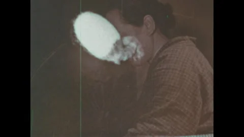 Japan 1960s: Silk moth emerging from a cocoon. Woman using a spinning wheel to Stock Footage 332085745