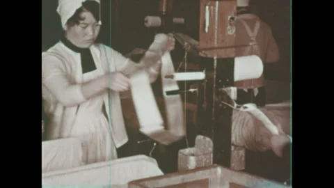 Japan 1960s: Spinning frames of silk thread. Women place sections of silk thread Stock Footage 332085875
