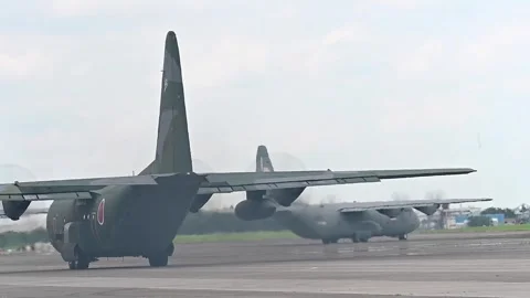 Japan Air Self-Defense Force and U.S. Air Force C-130 Hercules taxiing at Yokota Stock Footage 282867859