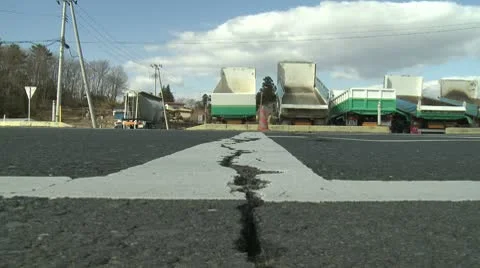 Japan Tsunami Aftermath - Cars Drive Over Crack In Road From Earthquake Stock Footage