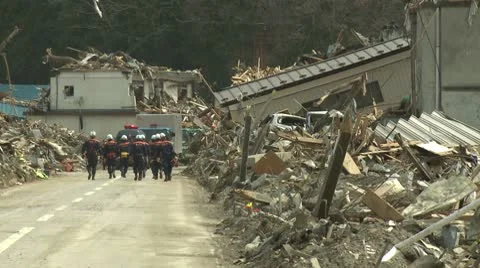 Japan Tsunami Aftermath - Rescuers Walk Through Destroyed Streets Stock Footage