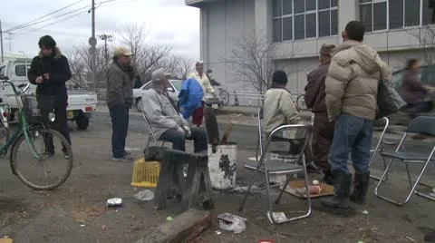 Japan Tsunami Aftermath - Survivors Sit Around Fire On Street Stock Footage
