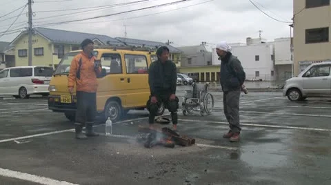 Japan Tsunami Aftermath - Survivors Stand Around Fire On Street Stock Footage